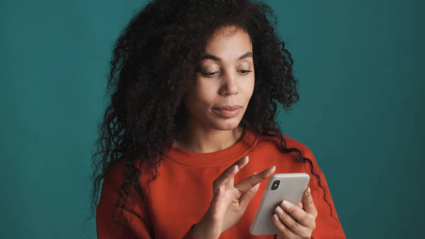 istock Attractive Afro woman chatting with friend using smartphone for 1373250877