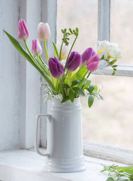 istock beautiful tulips on old white windowsill 1373252774