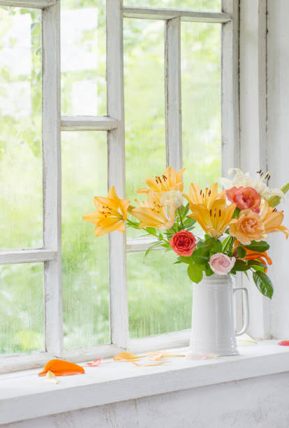 istock summer flowers in vase on background window with drops water 1373252778
