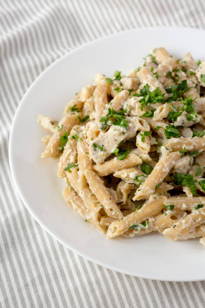 istock Homemade Chicken Alfredo Penne with Parsley on a white plate, side view. 1373254414