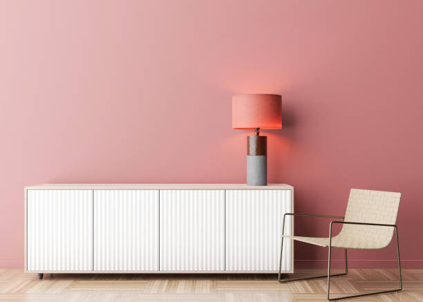 istock Empty pink wall in modern living room. Mock up interior in contemporary style. Free space, copy space for your picture, text, or another design. Sideboard, armchair, lamp. 3D rendering. 1373258024
