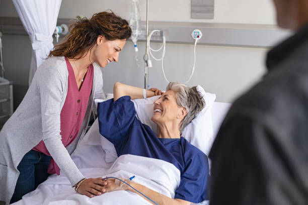 istock Smiling daughter and son visiting mother in hospital 1373258657