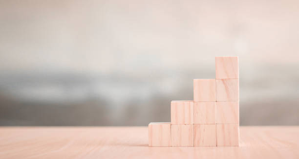 istock wood block stacking as step stair on wooden table 1373258840