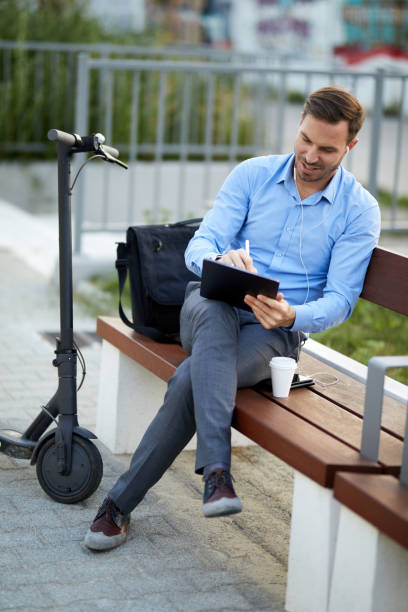 istock Businessman using digital tablet in the city park after scooter riding 1373260274