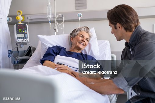 istock Son visiting his smiling mother at hospital 1373261458