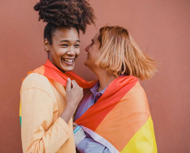 istock Multiracial girlfriends wrapping in rainbow flag 1373261469