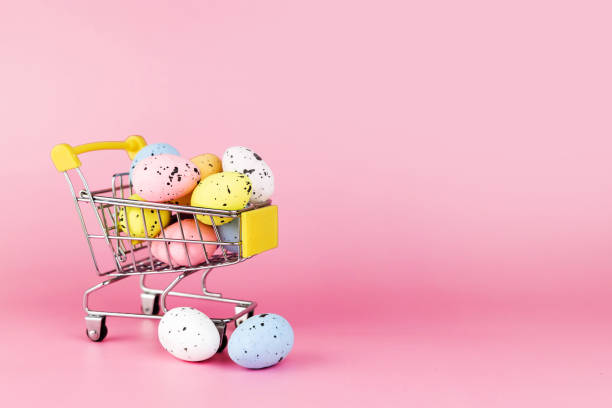 istock Colorful easter quail eggs in shopping cart on pink background. Copy space. Minimal Easter concept. 1373261568
