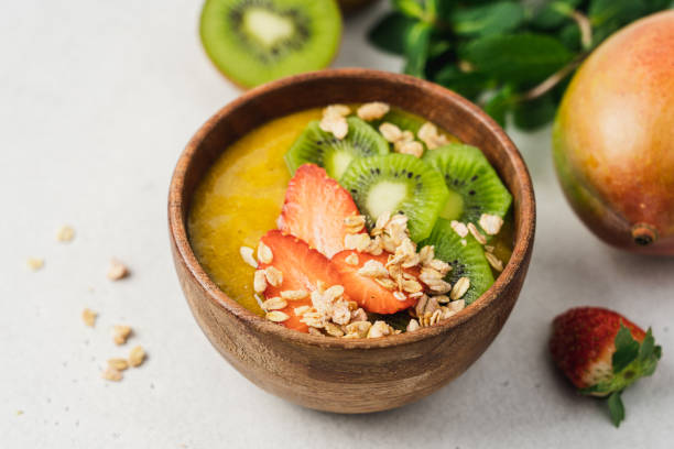 istock Mango smoothie wooden bowl with granola, kiwi and strawberries 1373263641