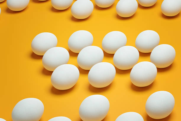 istock White chicken eggs on yellow background top view. Creative food minimalistic background. 1373264633