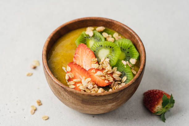 istock Mango smoothie wooden bowl with granola, kiwi and strawberries 1373264773