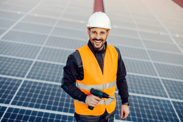 istock A smiling worker installing solar panels on the roof. 1373265622