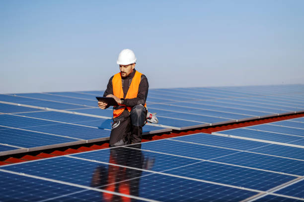 istock A supervisor kneeling and checking on correctness of solar panels on the roof. 1373265646