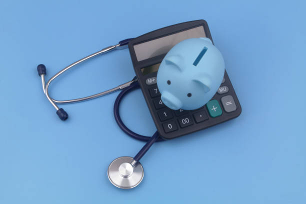istock Piggy bank, calculator and stethoscope blue background. 1373265887