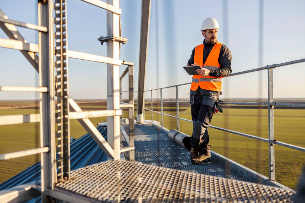 istock An industry worker standing on top of the silo and scrolling on tablet. 1373265986