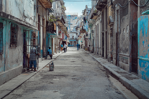 Havana, Cuba - August 26, 2022: A person walks by a run-down building in the Paseo del Prado district.