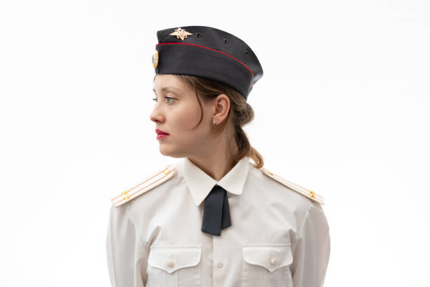 eine schöne junge russische polizistin in uniform mit mütze und schultergurten eines oberstleutnants und einem weißen hemd auf weißem grund - colonel stock-fotos und bilder