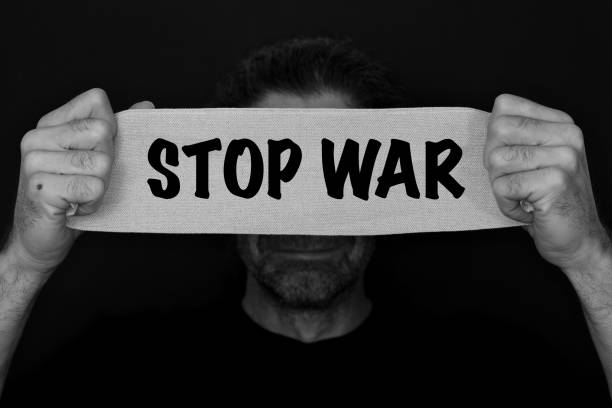istock Text message stop war. Bearded man with an anxious, fearful expression, with bandage banner in hand with the text STOP WAR. 1373267509