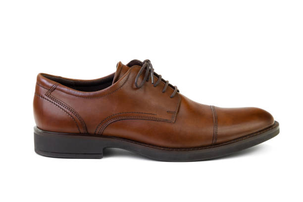 Single unbranded brown genuine leather men's shoe isolated on white background, side view. Fashion and shopping concept