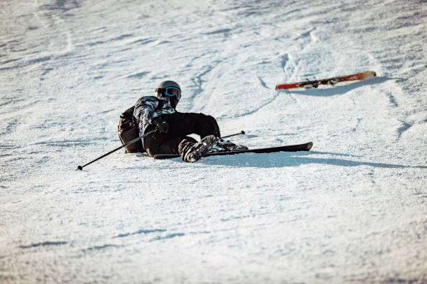joven esquiador masculino que tiene un accidente en una estación de esquí - ski insurance fotografías e imágenes de stock