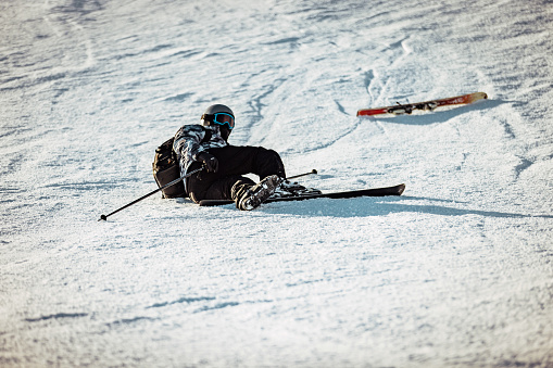 Young male skier having an accident on a ski resort