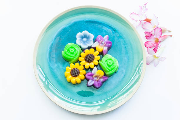 istock Pretty flower shaped desserts in a green plate isolated on white 1373271793