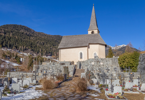 Church and cemetery in a village named St Felix in South Tyrol at winter time