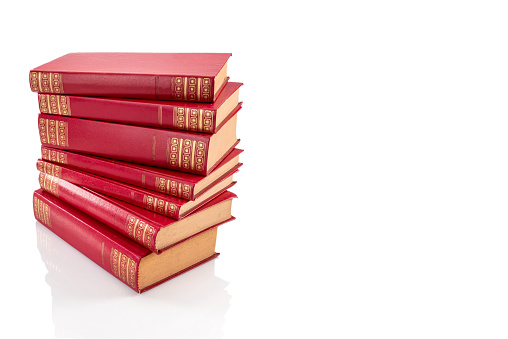Stack of red vintage books with golden decorations on hard leather cover, isolated on white, clipping path, copy space