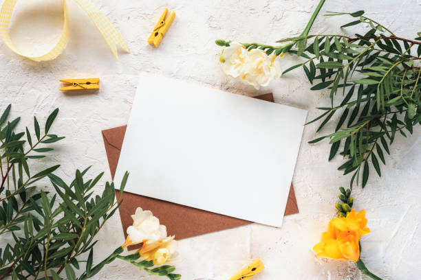 istock Envelope with blank paper sheet on textured background with flowers and decorations. Spring holidays concept. Top view, flat lay, mockup 1373281012