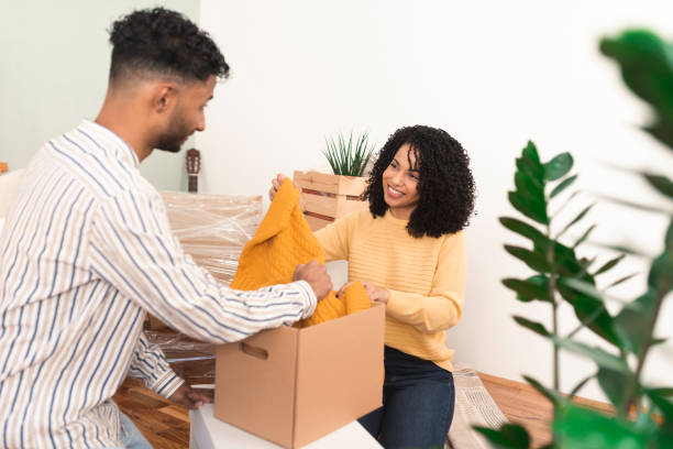 istock Husband helping his wife with unpacking while moving into the new apartment 1373281178