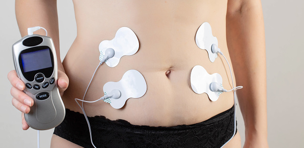 A modern electronic punctuator for burning belly fat and strengthening muscles on the girl's body