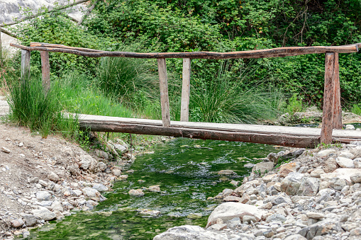 A small wooden bridge over a mineral stream starting from the Bagni San Filippo Mineral Water spring