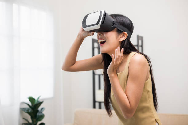 istock Young asian woman put on vr glasses into virtual simulated world. Future technology digital cyber universe. Person Enjoying an Experiences of Virtual World. 1373287712