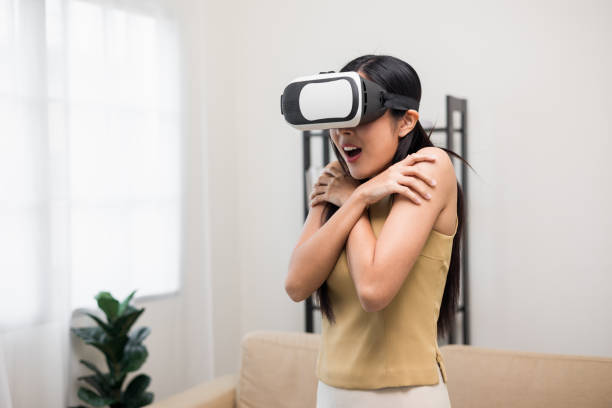 istock Young asian woman put on vr glasses into virtual simulated world. Future technology digital cyber universe. Person Enjoying an Experiences of Virtual World. 1373287719