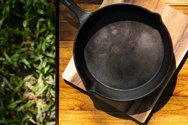 istock Iron pan and camping accessory on wood table. Equipment for camping in forest. In summer with sunlight. 1373287731