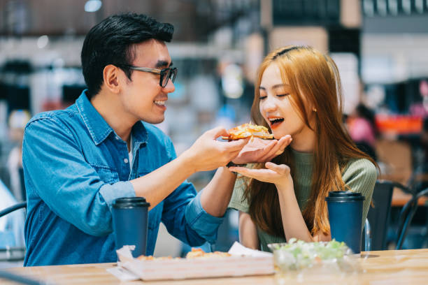 istock Young Asian couple having lunch together in cafe 1373288061