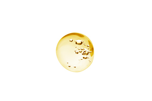 Yellow Drop of cosmetic cream, serum, oil with transparent gel texture with micro bubble on white background Beauty concept, macro