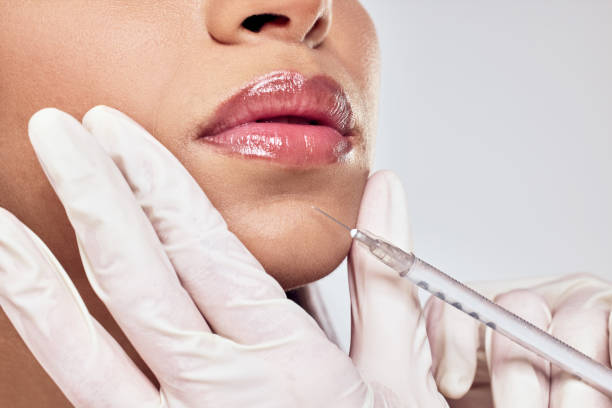 Shot of a woman having her chin injected with botox against a studio background One syringe for all your dreams fillers stock pictures, royalty-free photos & images