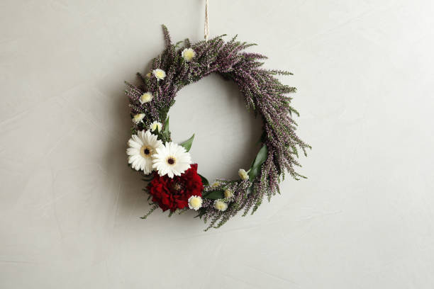 istock Beautiful autumnal wreath with heather flowers hanging on light grey background. Space for text 1373290812