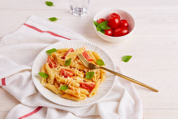 istock Pasta penne with tomatoes, basil on a light background. 1373294918