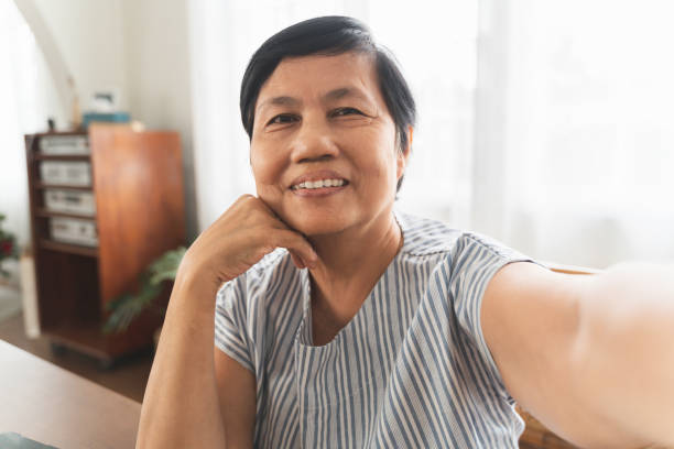 istock Smiling Asian senior woman using smartphone taking selfie. 1373295624
