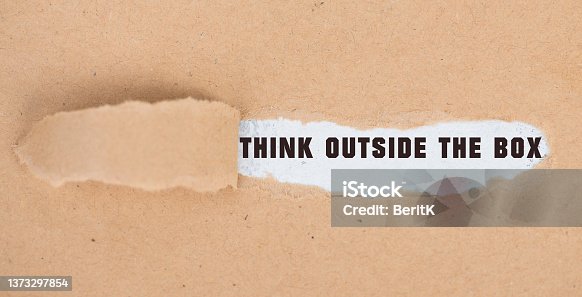 istock Think outside the box is standing on pieces of white paper, brainstorming for new ideas, being innovative, business concept 1373297854