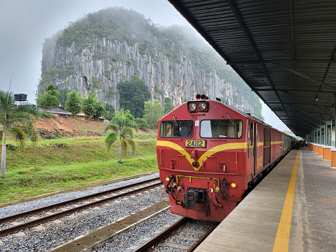 Kelantan, Malaysia - 21 FEBRUARY 2022 : Train stopped in Gua musang station during foggy morning before continuing journey to the next station.