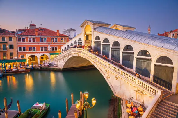 Venice, Italy at the Rialto Bridge over the Grand Canal at twilight.