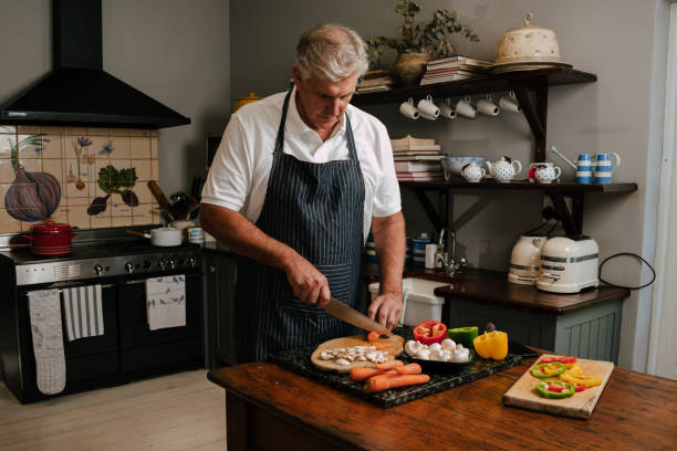 istock Caucasian male cooking in kitchen chopping vegies 1373298545