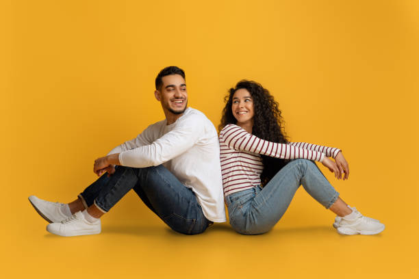 istock Romantic Middle Eastern Couple Sitting Back To Back Over Yellow Studio Background 1373300546