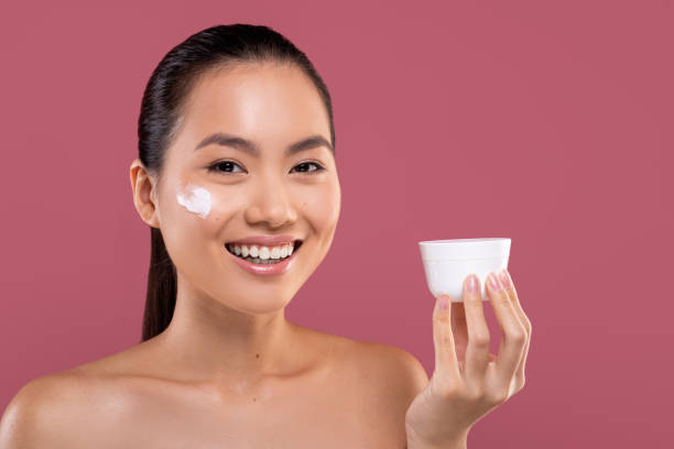 istock Beautiful asian lady holding white jar with cream 1373300879