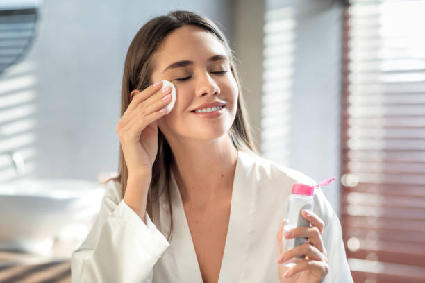 Beautiful Smiling Woman Cleansing Skin With Micellar Water And Cotton Pad stock photo
