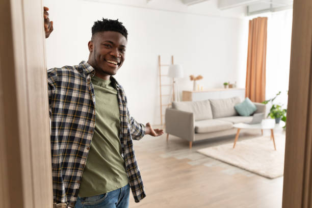 istock Black Man Opening Door Gesturing Inviting To Come In Indoor 1373301378