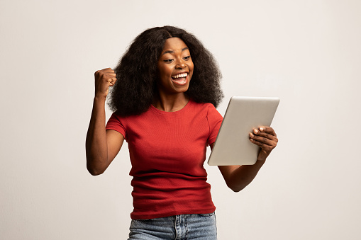 Online Win. Portrait Of Overjoyed Black Female Celebrating Success With Digital Tablet, Cheerful Young African American Woman Raising Clenched Fist And Exclaiming With Excitement, Copy Space