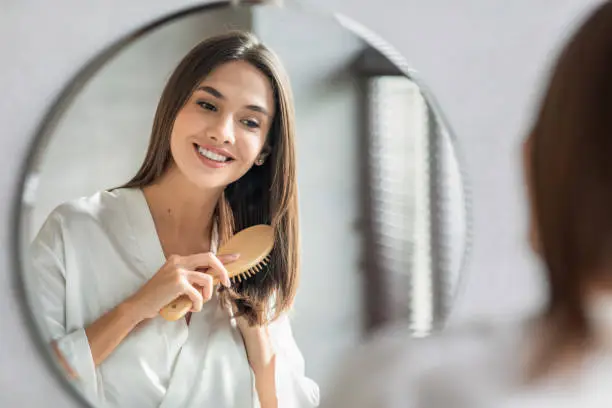Photo of Beauty Routine. Pretty Woman Combing Her Beautiful Hair With Brush